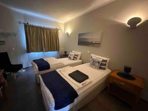 - une chambre avec 2 lits, un bureau et une fenêtre dans l'établissement Casa Buccaneer, 2 Bedroom Garden Apartment in Praia da Luz, à Luz