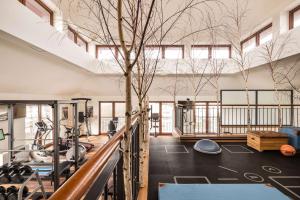 einen Fitnessraum mit Trainingsgeräten und einem Baum in der Unterkunft Park-Hotel Hagenbeck in Hamburg