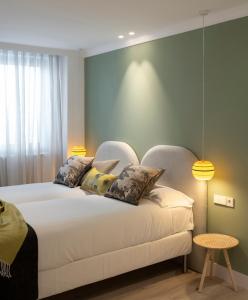 a bedroom with a large white bed with two pillows at Santiago Apartments Bilbao in Bilbao