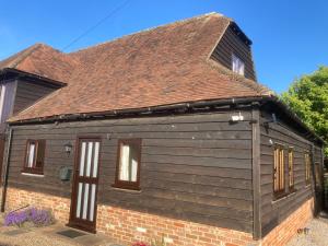 a small house with a brown roof at The Manger at Bethersden, nr Tenterden and Ashford in Bethersden