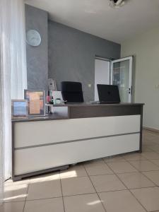 an office with a reception desk with two laptops on it at Guesthouse Iceberg in Ravda