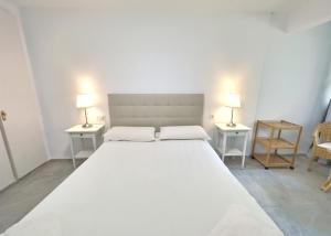1 dormitorio con 1 cama blanca grande y 2 mesas en Amazing Sea Views over Marbella Port, en Marbella