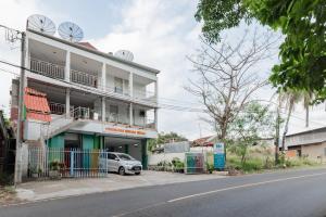 a building with a car parked in front of it at RedDoorz Syariah at Pantai Pelabuhan Ratu in Sukabumi