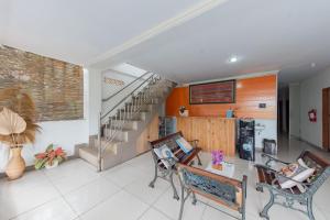 a living room with two chairs and a staircase at RedDoorz Syariah at Pantai Pelabuhan Ratu in Sukabumi