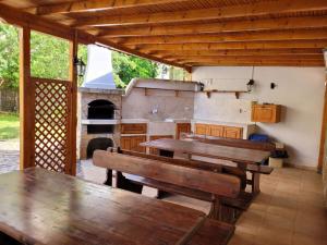 an outdoor kitchen with wooden tables and an oven at Guesthouse Iceberg in Ravda