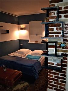 a bedroom with a bed next to a brick wall at Guest house Meri Poppins in Dedoplis Tskaro