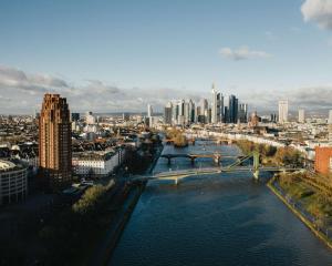 a view of a city with a river and a bridge at Lindner Hotel Frankfurt Main Plaza, part of JdV by Hyatt in Frankfurt