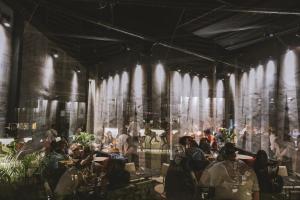 Sapiens Hotel في طشقند: تقديم مطعم فيه ناس جالسين على الطاولات