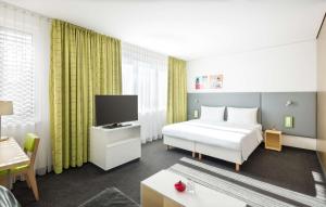 a hotel room with a bed and a tv at Lindner Hotel Frankfurt Sportpark, part of JdV by Hyatt in Frankfurt/Main +71 photos