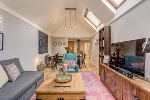 a living room with a couch and a tv at Apple Tree Cottage in Oxford