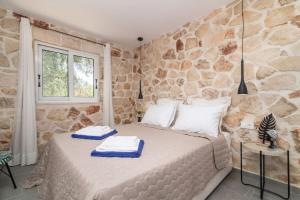 a bed in a room with a stone wall at Villa Maria in Laganas