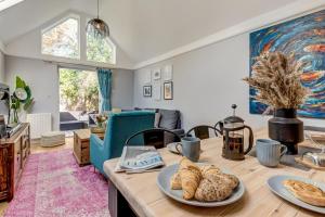 牛津的住宿－Apple Tree Cottage，厨房以及带木桌和面包的客厅。