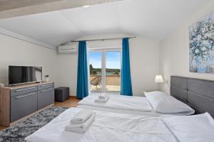 a bedroom with a large bed and a television at Minerva Hotel in Medulin