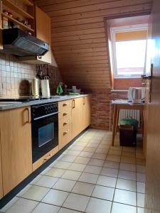 a kitchen with wooden cabinets and a stove top oven at Gisela Hollmann in Groß Wittensee