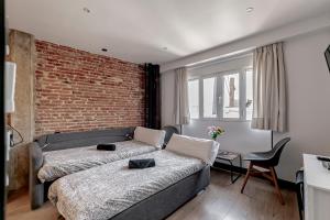 a bedroom with a bed and a brick wall at Ático Centro de Madrid in Madrid