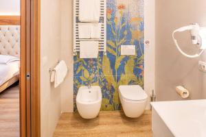 a bathroom with a toilet and a sink at Hotel Centrale in Garda