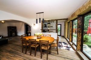 una cucina e una sala da pranzo con tavolo e sedie in legno di Cabana Valea Rea, Boga a Boga