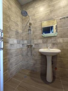 un bagno con lavandino e doccia di Ananuri Cottages a Ananuri Altre 37 foto