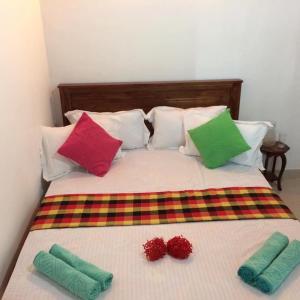 una cama con almohadas coloridas encima en Villa25 Homestay free pick up from the center, en Kandy