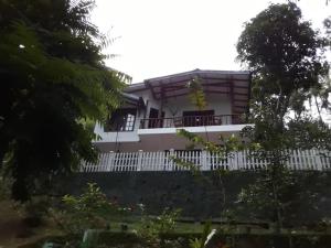 una casa con una valla blanca en Villa25 Homestay free pick up from the center, en Kandy