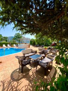 a patio with tables and chairs next to a pool at Sineva Del Sol Apartments in Sveti Vlas