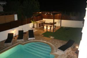 an overhead view of a swimming pool with chairs and a table at Dream House Latchi Villa in Polis Chrysochous