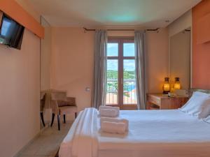a bedroom with a bed with two towels on it at Fiscardo Bay Hotel in Fiskardo +37 photos