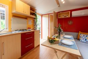 a kitchen with a table with a bowl of fruit on it at L'Estrellus, mobil-home climatisé au cœur du vignoble à quelques mètres de la mer in Hyères