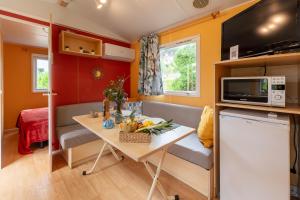 a small kitchen and living room in a tiny house at L'Estrellus, mobil-home climatisé au cœur du vignoble à quelques mètres de la mer in Hyères