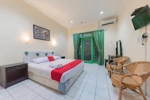 1 dormitorio con 1 cama y sillas en una habitación en RedDoorz @ Jalan R.E. Martadinata Sukabumi en Sukabumi