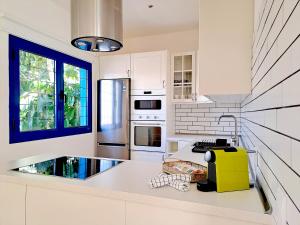 eine Küche mit weißen Schränken und einem gelben Gerät in der Unterkunft Villas Veaco Bahiazul with private pool in Corralejo