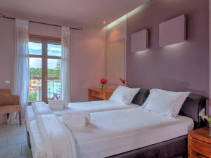 a bedroom with two beds and a window at Fiscardo Bay Hotel in Fiskardo