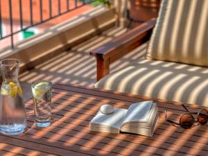 a table with a book and a bottle and glasses at Fiscardo Bay Hotel in Fiskardo