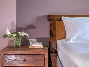 a bedroom with a bed and a table with a vase of flowers at Fiscardo Bay Hotel in Fiskardo