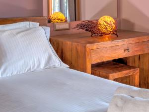 a bedroom with a bed and a wooden table with a night stand at Fiscardo Bay Hotel in Fiskardo