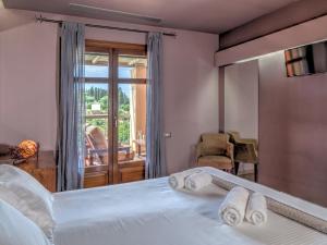 a bedroom with a bed with towels on it at Fiscardo Bay Hotel in Fiskardo