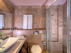 a bathroom with a shower and a toilet and a sink at Fiscardo Bay Hotel in Fiskardo
