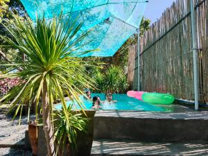 two people in a swimming pool in a backyard at Playa de Bombora Inn in Cabugao