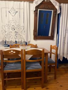 einen Esstisch mit Stühlen und einem Spiegel in der Unterkunft Emporios Traditional Sea View House in Emporeiós