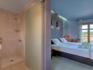 a bedroom with a large bed and a shower at Fiscardo Bay Hotel in Fiskardo