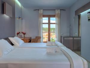 a bedroom with two beds and a window at Fiscardo Bay Hotel in Fiskardo
