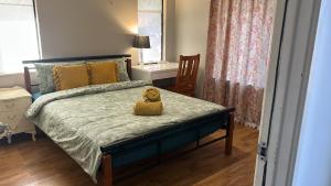 Un dormitorio con una cama con un osito de peluche. en Nice house in canning vale en Perth