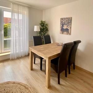 ein Esszimmer mit einem Holztisch und Stühlen in der Unterkunft Apartment Casa Heideweg mit TG direkt an der Heide in Dresden