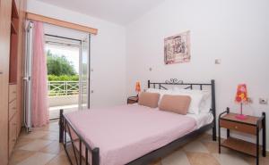 a bedroom with a bed and a balcony at Villa Andreas A Private Paradise in Mouzákion