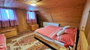 ein Schlafzimmer mit einem Bett in einer Holzhütte in der Unterkunft Chata Holý Vrch - oáza kľudu a pokoja in Krupina