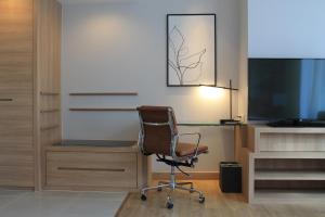 a office with a desk and a chair and a television at Courtyard by Marriott Bangkok in Bangkok