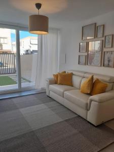 uma sala de estar com um sofá e uma grande janela em Elegante monolocale Elmas Cagliari em Elmas