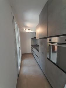 a kitchen with stainless steel appliances and a hallway at Elegante monolocale Elmas Cagliari in Elmas +4 photos