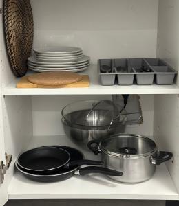 a kitchen with pots and pans and plates on shelves at Apart Nissa Bella Seafont / Promenade des Anglais in Nice