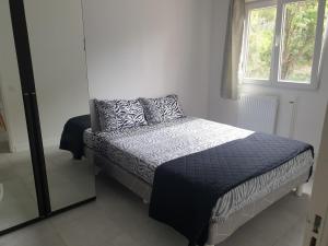 a bed in a white room with a window at Appartements renové 2023 proche aéroport 5min, gare sncf 2 min, tramway au pied de l'immeuble , Parking possible, Renovated apartments 2023 near the airport 5 min, train station 2 min, tram next to the building 1 min, Parking possible in Nice